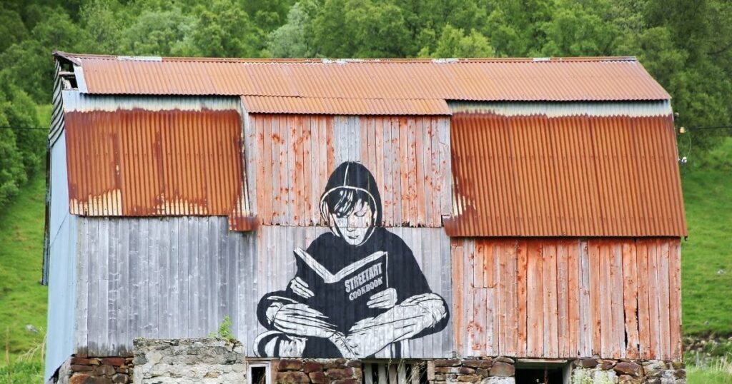 壁に描かれた本を読む男の子